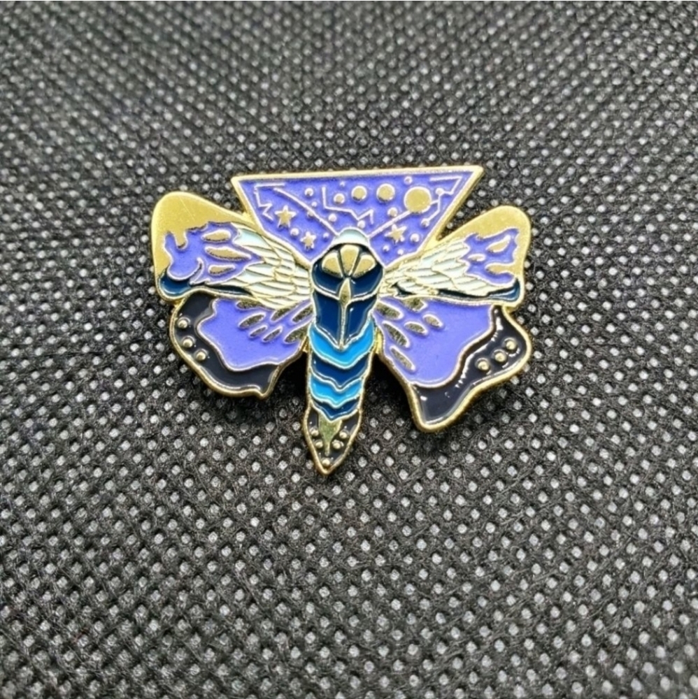 Glow in the dark moth enamel pin. Glows green with gold metal backing.